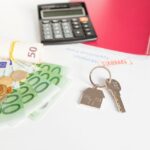 a key, calculator, and cash on an office table