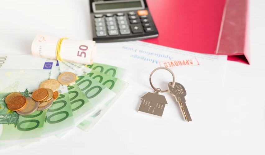 a key, calculator, and cash on an office table